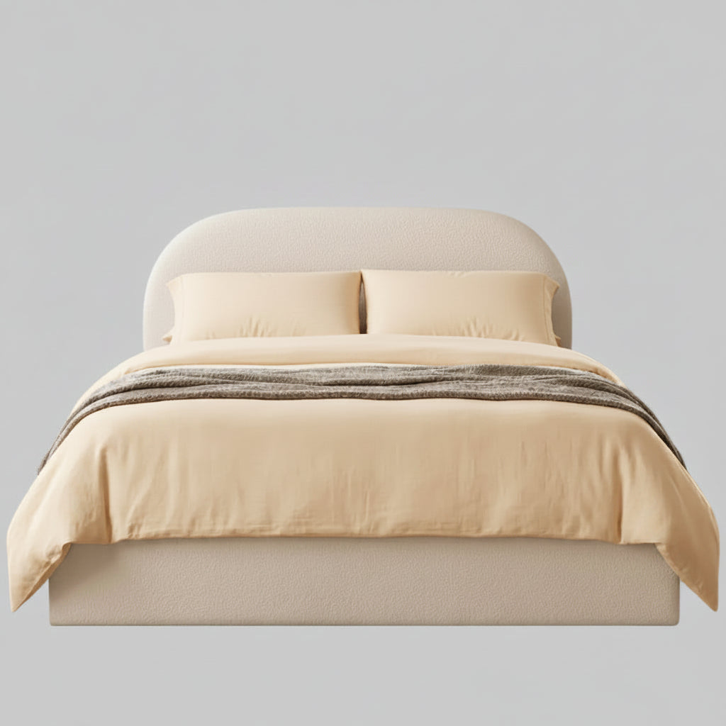 A neatly made bed with white bedding, two white pillows, a textured beige headboard, and a beige footboard, centered against a solid gray background.