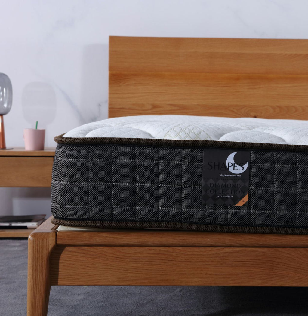 Mattress on a wooden bed frame with a minimal background