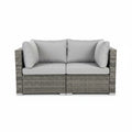 Gray outdoor sofa with cushions on a balcony at night