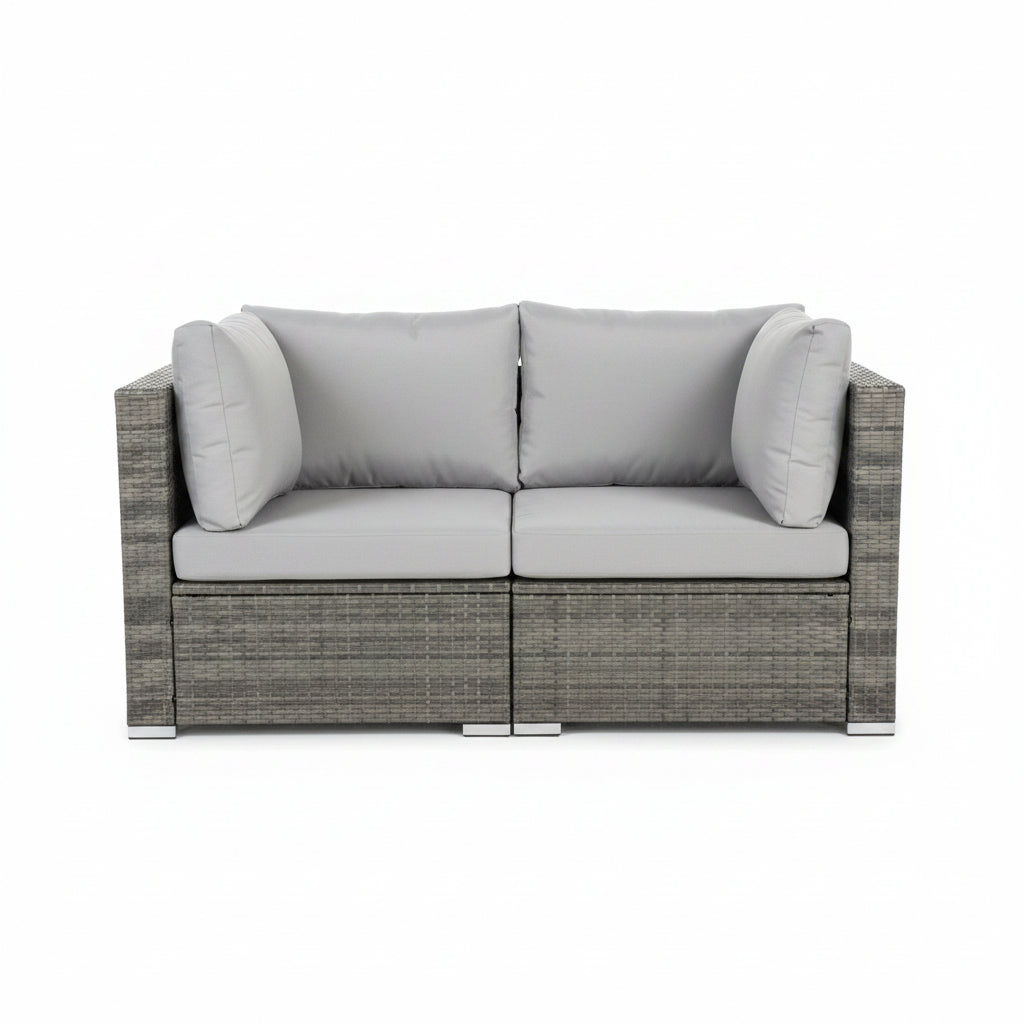 Gray outdoor sofa with cushions on a balcony at night