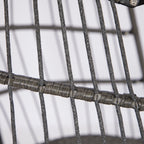 Close-up of a woven wire chair with a plain background