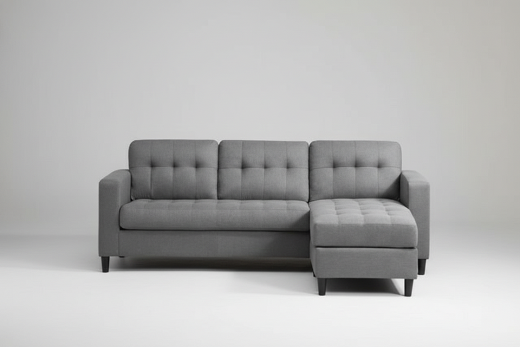 Gray sectional sofa in a living room setting with a white wall and wooden floor.