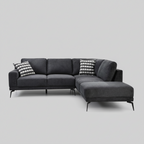 Gray sectional sofa in a living room with decorative pillows and a lamp.