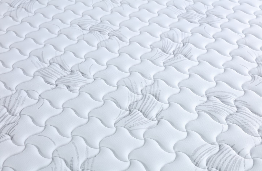 Close-up of a textured white mattress surface