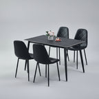 Dining set with a table and four chairs in a room with a rug and window.