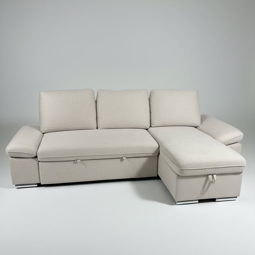 Gray sectional sofa in a room with a yellow mat and green leaves on a wooden floor.