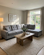 Living room with a gray sectional sofa, wooden coffee table, and framed picture on the wall.