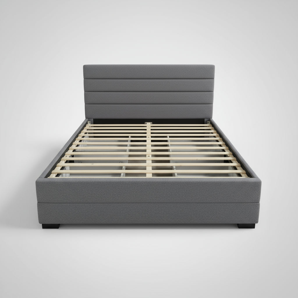 Gray upholstered bed frame with wooden slats in a warehouse setting