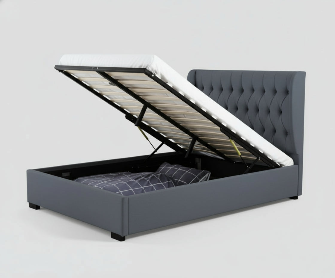 Gray upholstered bed with storage compartments in a room with a window and decor.