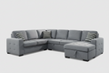 Gray sectional sofa in a living room with large windows and a rug.