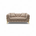 Beige tufted sofa with gold legs in a showroom setting