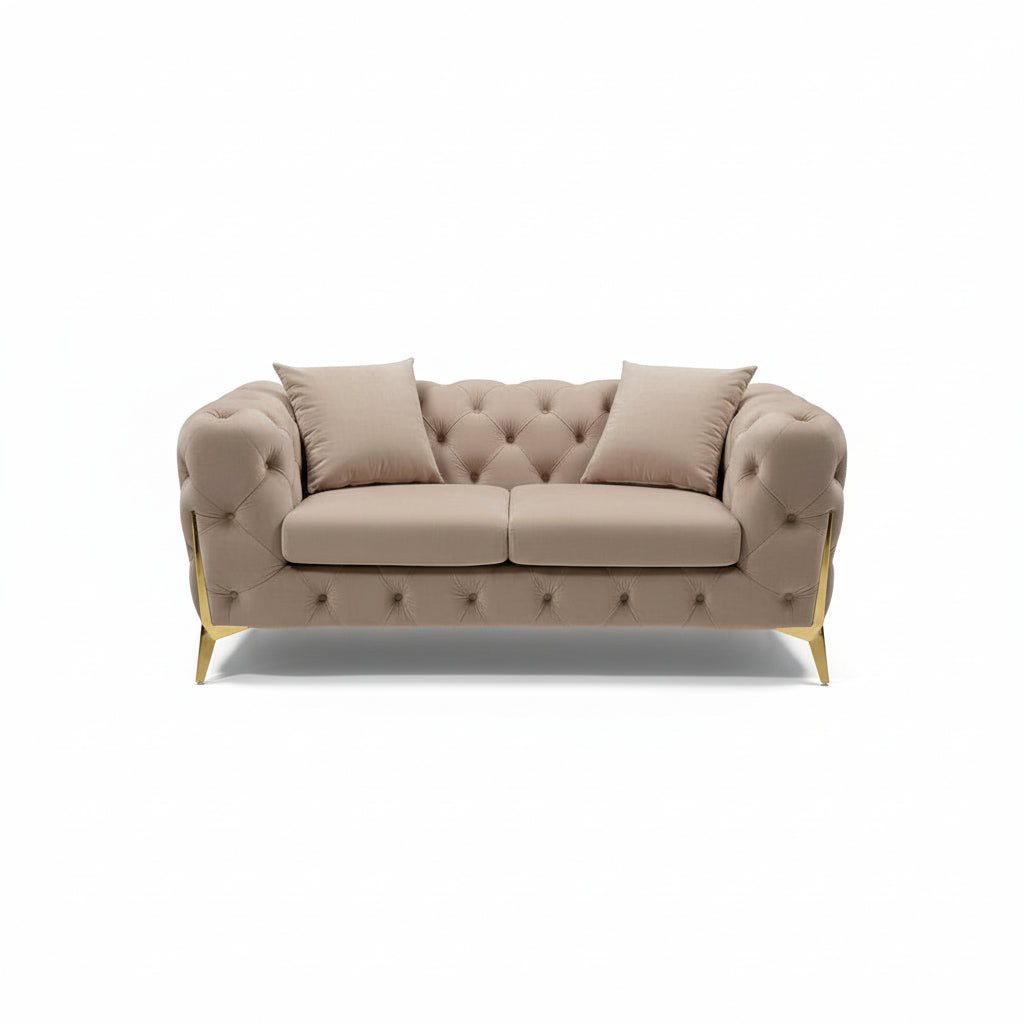 Beige tufted sofa with gold legs in a showroom setting